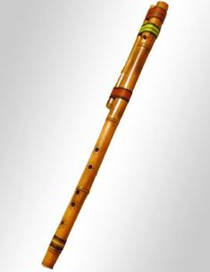 an old wooden flute with green and gold trimmings on it's end