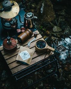 an assortment of coffee and tea on a picnic table in the middle of a stream