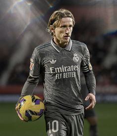 a man holding a soccer ball on top of a field