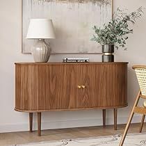 a wooden cabinet sitting next to a lamp on top of a table in a living room