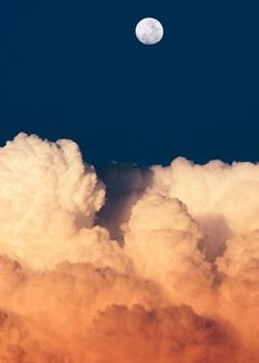 the full moon is seen through clouds in this photo