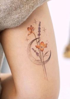 a woman's thigh with flowers on it and the moon in the sky behind her