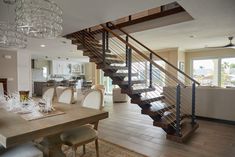 a dining room table with chairs and a chandelier hanging from it's ceiling