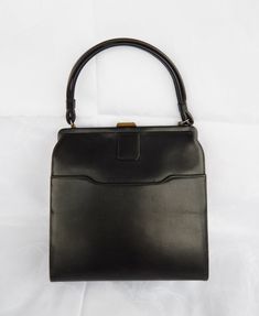 Vintage Black Handbag, Elegant Black Purse 1960's Classic Frame Bag Top Clasp, Mid Century Fashion  ♥ Beautiful true vintage c. 1960's handbag made of black faux leather with a beige vinyl interior. It has a doubled carrying handle and a brass top closure. One main compartment with interior zippered wall pocked and one exterior frontal slip pocket. This vintage purse is in a good condition: very clean, stain free interior, both the clasp and the interior zipper work great, there are surface scuf Vintage Black Shoulder Bag With Hasp Closure, Black Vintage Bags For Daily Use, Vintage Square Box Bag, Vintage Black Square Shoulder Bag, Vintage Square Evening Bag For Formal Occasions, Vintage Rectangular Bags For Vintage Events, Vintage Rectangular Bags For Events, Vintage Square Evening Bag, Classic Rectangular Evening Bag For Vintage Events