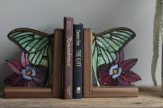 two bookends with butterflies on them sitting next to each other