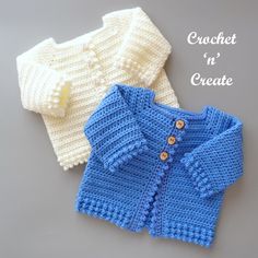 two crocheted sweaters sitting next to each other