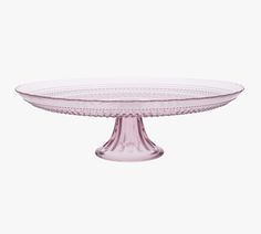 a pink glass cake plate on a white background