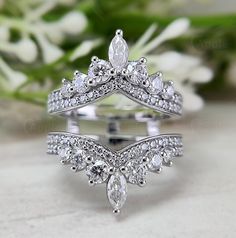 a close up of a wedding ring on a table with flowers in the background