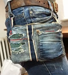 a person with their back turned to the camera, wearing jeans and holding a cell phone