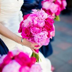 a bride holding a bouquet of pink flowers