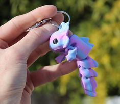 a hand holding a keychain shaped like a pony