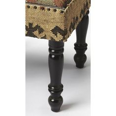 an upholstered foot stool with black legs and floral print fabric on the seat