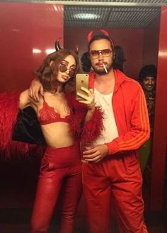 a man and woman dressed in red posing for a selfie with their cell phone