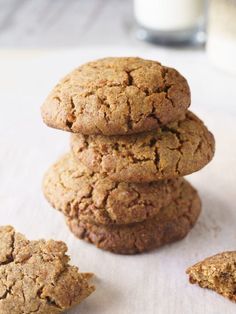 a stack of cookies sitting on top of a table next to a glass of milk