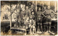 an old black and white photo of children in native american clothing posing for the camera