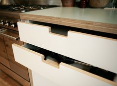 an open drawer in a kitchen next to a stove