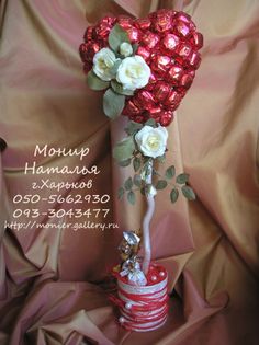 a bouquet of roses in a vase on top of a stack of stacked red and white plates