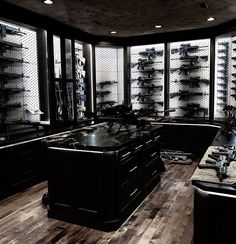 a large kitchen with lots of counter space and shelves full of glasses on the wall