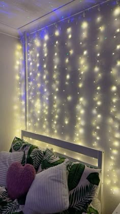 a bed with pillows and lights on the wall