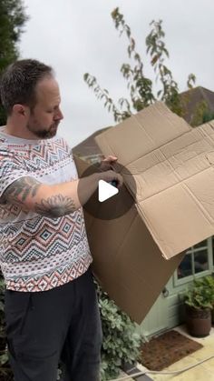 a man holding a large cardboard box in his hands