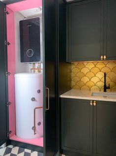 a pink and black bathroom with a white water heater in the shower stall next to it