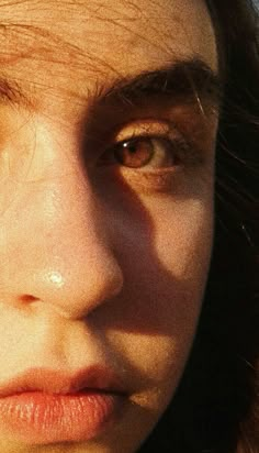 a close up of a woman's face with the sun shining on her