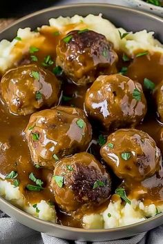 meatballs covered in gravy on top of mashed potatoes