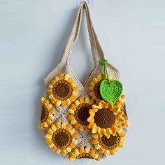 a crocheted sunflower purse hanging on a wall