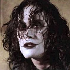 a close up of a person with long hair and black lipstick on their face,