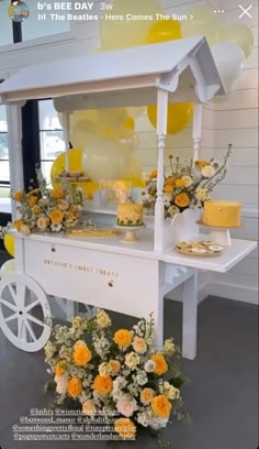 an ice cream cart decorated with flowers and balloons