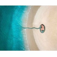 an aerial view of a woman laying on the beach