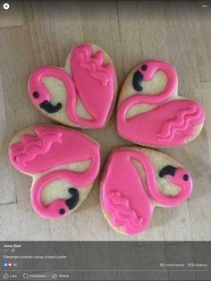 four decorated cookies in the shape of pink flamingos