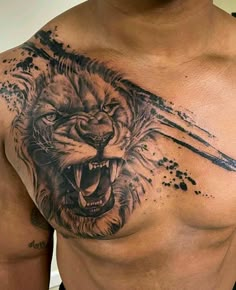 a man's chest with a tattoo of a lion on it and ink splatters