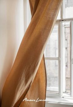 the curtain is hanging in front of an open window with white walls and windowsills