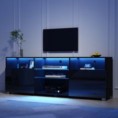 an entertainment center with blue lighting and a flat screen tv