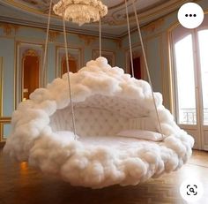 a bed made out of foam is suspended by chains in the middle of a room