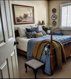 a bed sitting in a bedroom next to a window covered in blue and white blankets