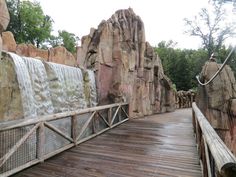 a wooden walkway leading to a waterfall