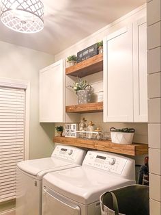 a washer and dryer sitting in a room next to each other on top of cabinets