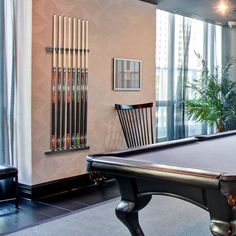 a pool table is in the middle of a room with chairs and a large window