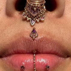 a woman's nose with various piercings on it and the top part of her lip