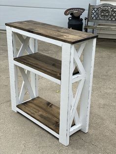 a white and brown table sitting on top of a cement ground