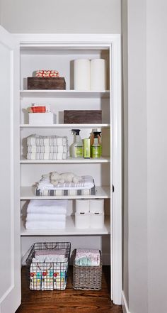 an organized pantry with white shelving and baskets on the floor, including toiletries