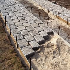 several rows of stone blocks are lined up in the dirt and ready to be laid