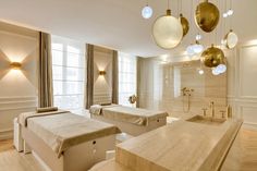 two beds in a room with lights hanging from the ceiling and some bathtubs