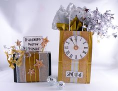 a gold gift bag with silver stars and a clock on it is next to a new year's present