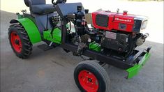 a green and red tractor sitting on top of cement