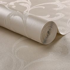 a roll of white paper sitting on top of a bed next to a wallpaper