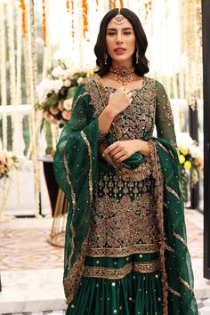 Dark Green Gharara Kameez for Pakistani Mehndi Wear is in chiffon shirt featuring heavy work. Paired with flared raw silk gharara with heavy zardozi work. Organza Dupatta with heavy border work accentuates the whole look. Dark Green Gharara Shirt: Bride love is in the air! NameerabyFarooq presents a dark green shirt rendered with golden embroidery and is enhanced with the magic of Resham, pearls, Sitara, tilla and dabka to complete the feeling of your reception day. The shirt is emphasized with Net Anarkali Dresses, Green Gharara, Tailor Design, Dark Green Shirt, Mehndi Outfit, Pakistani Mehndi, Pakistani Fashion Party Wear, Beautiful Suit