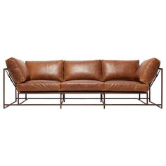 a brown leather couch with metal frame and backrests on an isolated white background